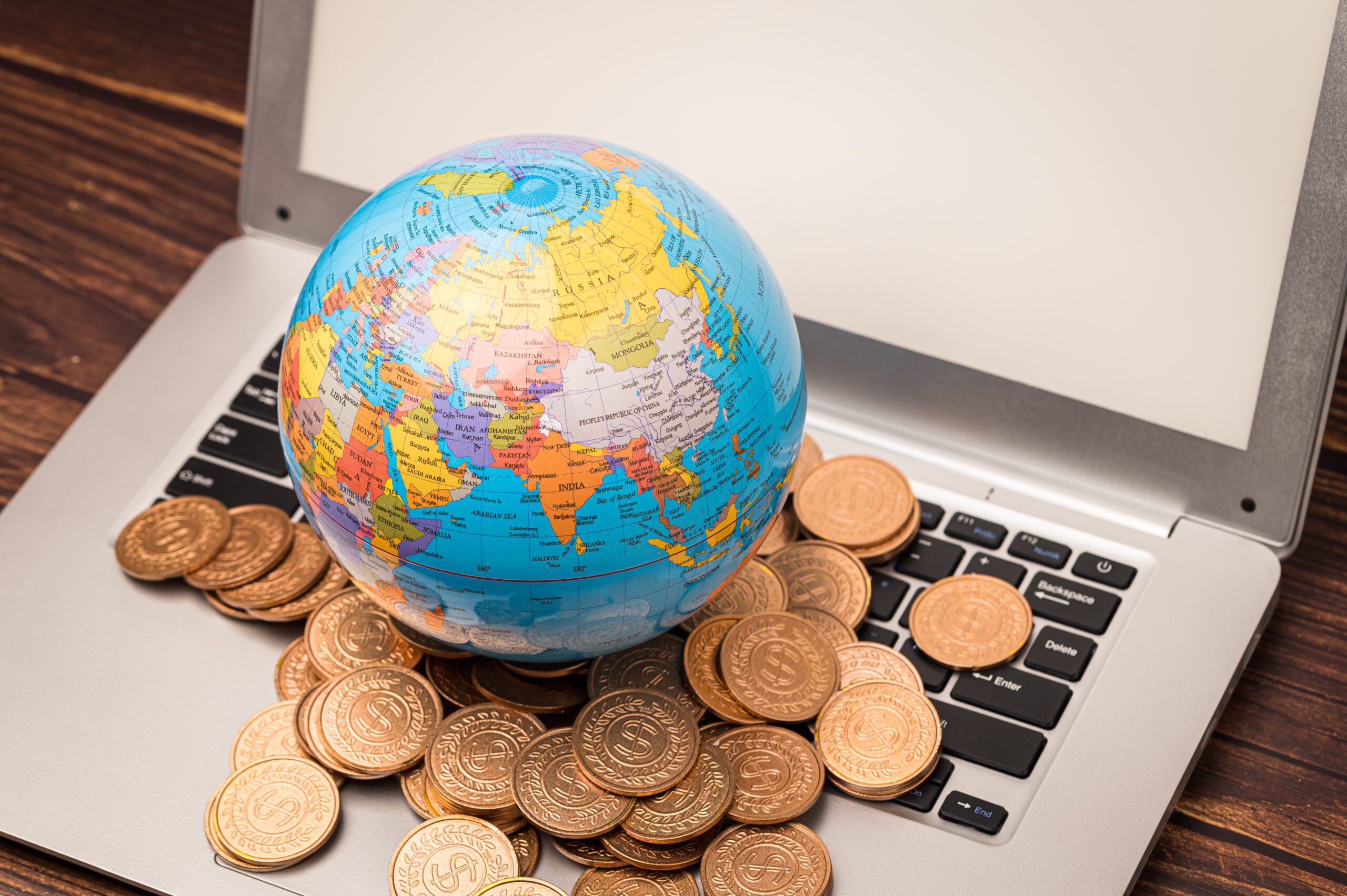 A closeup of the globe's model with coins on the laptop.