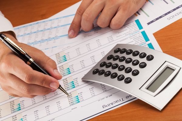 Accountant working on ledger with calculator