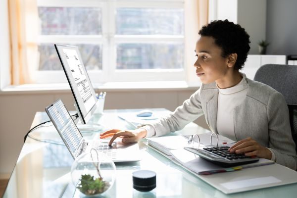 Tax manager at work sitting in front of a desktop computer