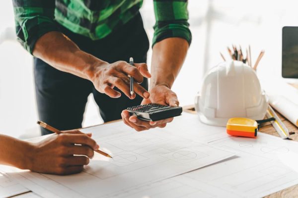 engineers-work-as-a-team-with-blueprints-for-archi-2023-11-27-04-56-49-utc-scaled