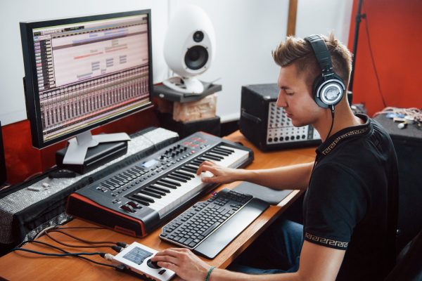 sound-engineer-in-headphones-working-and-mixing-music-royalty-finances-entertainment-industry-accounting-tax-implications-streaming-financial-issues